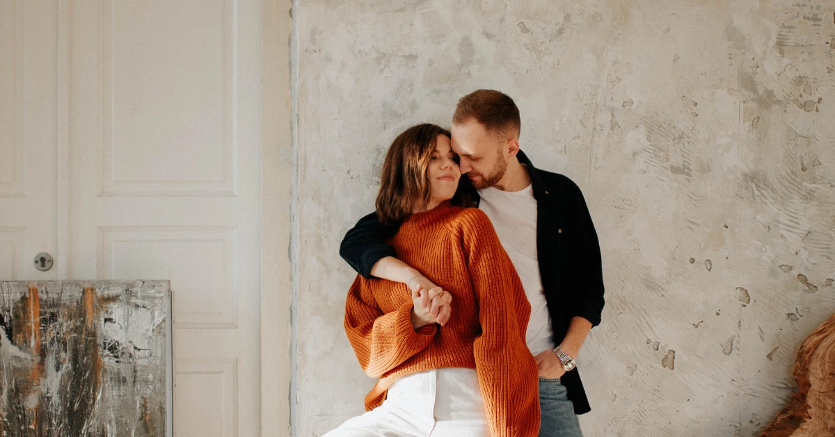 a couple leaning against the wall while hugging