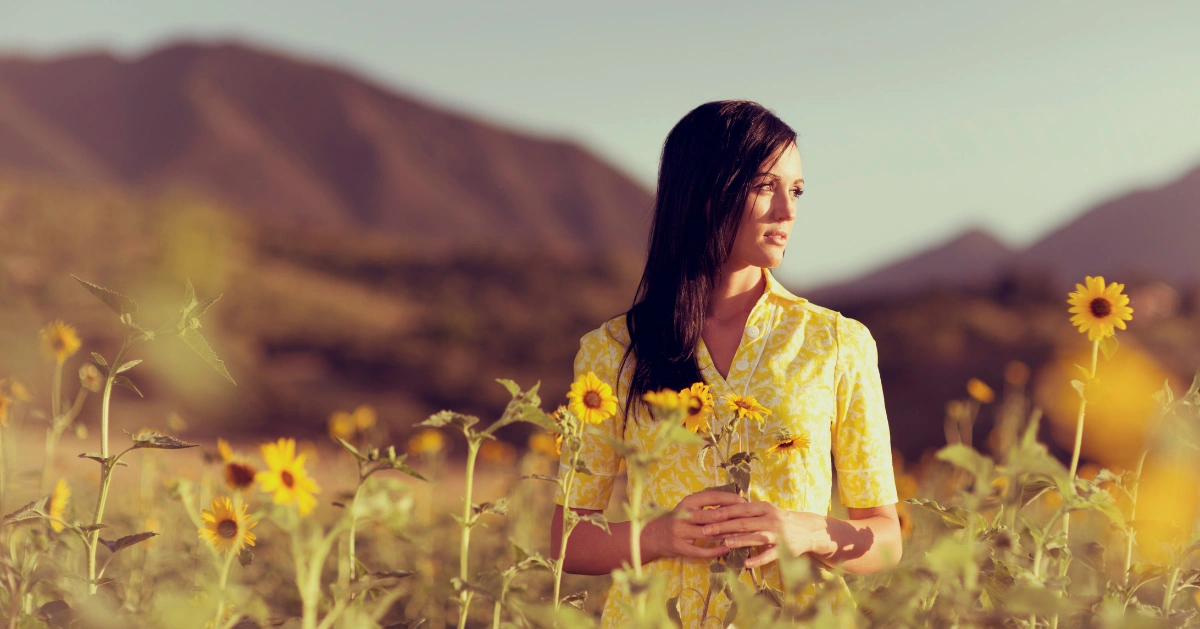 a girl standing in a field of flowers
