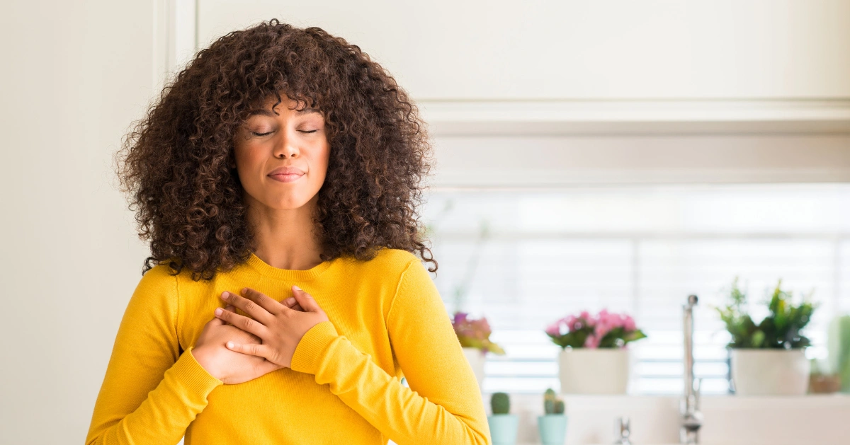 A lady with her hands on her chest feeling grateful