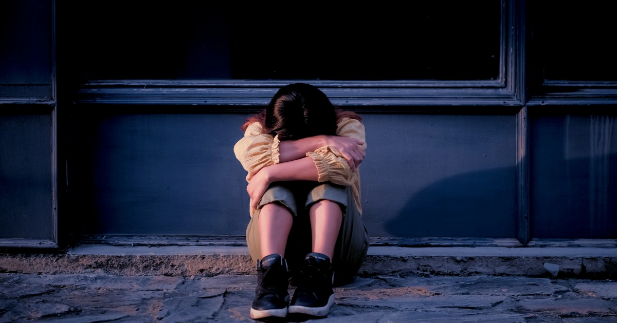 Teen sitting with head down