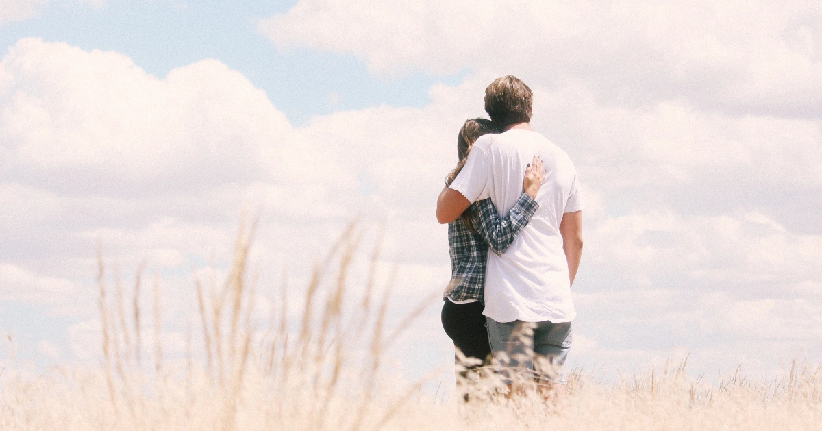 a couple embracing in the middle of a field