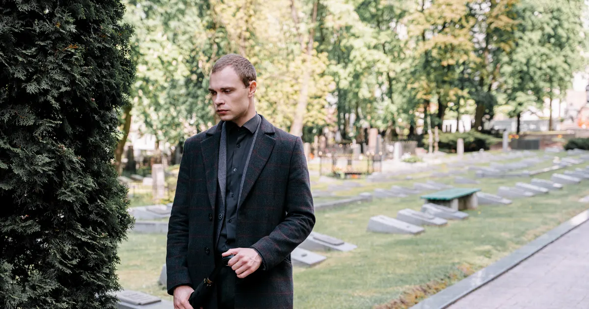 a guy standing at a cemetery.