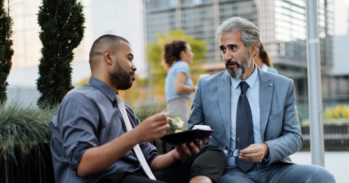 a guy sitting with his older mentor