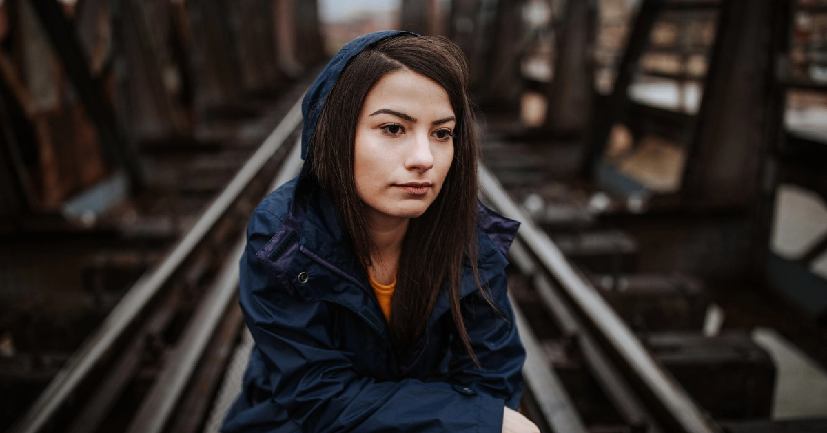 a girl sitting on a bridge