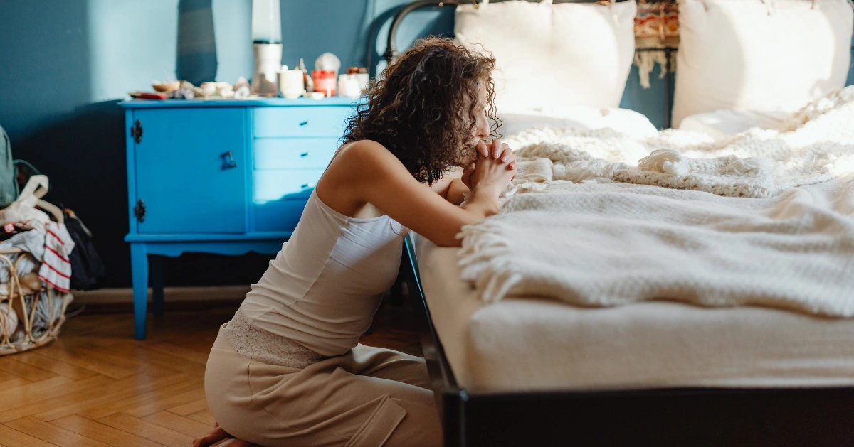 Girl praying in her room.