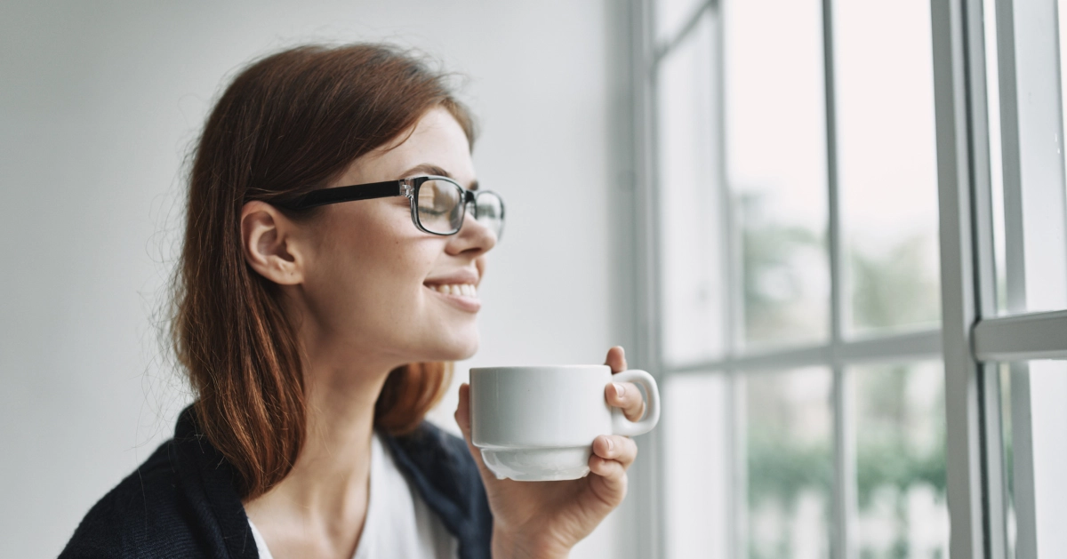 a lady holding a cup of coffee smiling