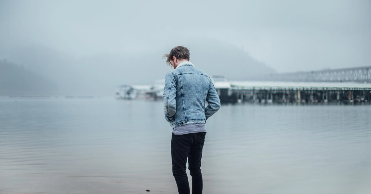 a guy walking on the beach alone