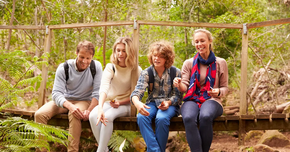 a family sitting on a tree trunk