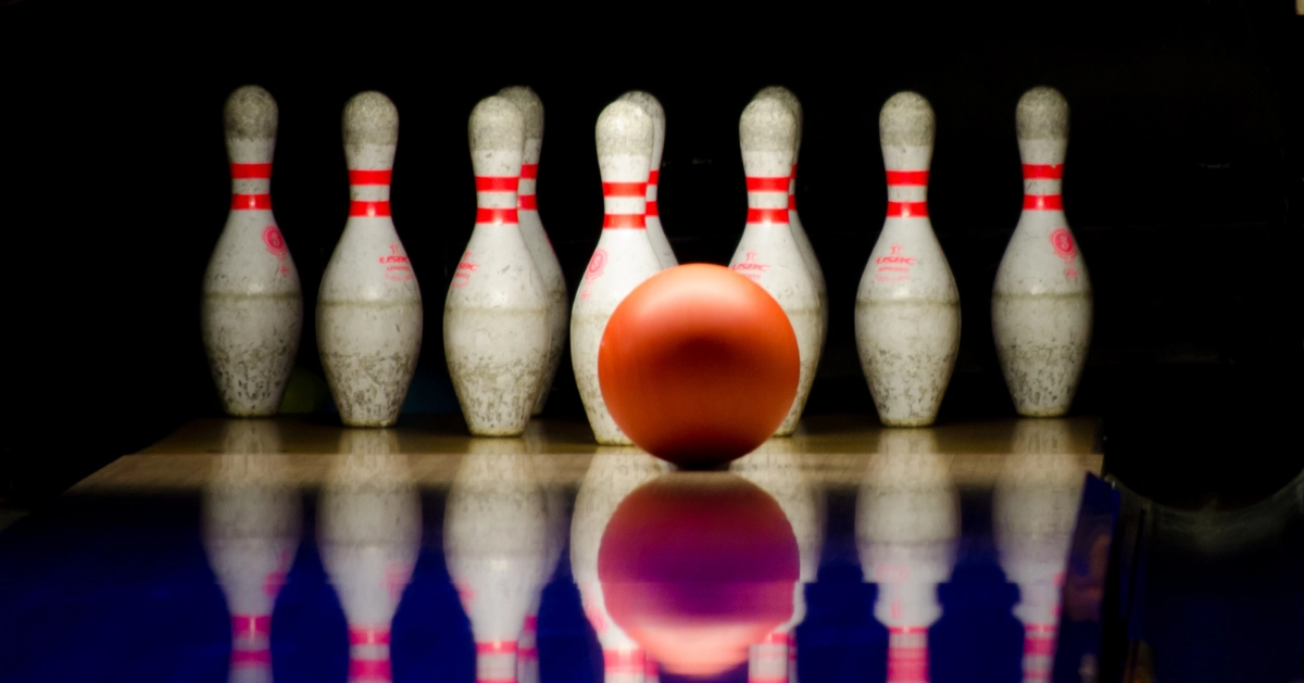 A bowling ball about to hit pins.