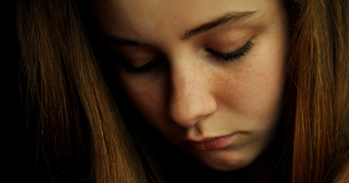 a girl looking down. she's sad