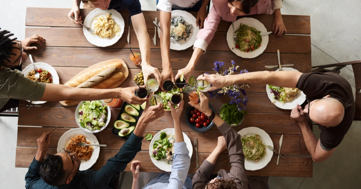 A group of friends at dinner cheering their drinks.