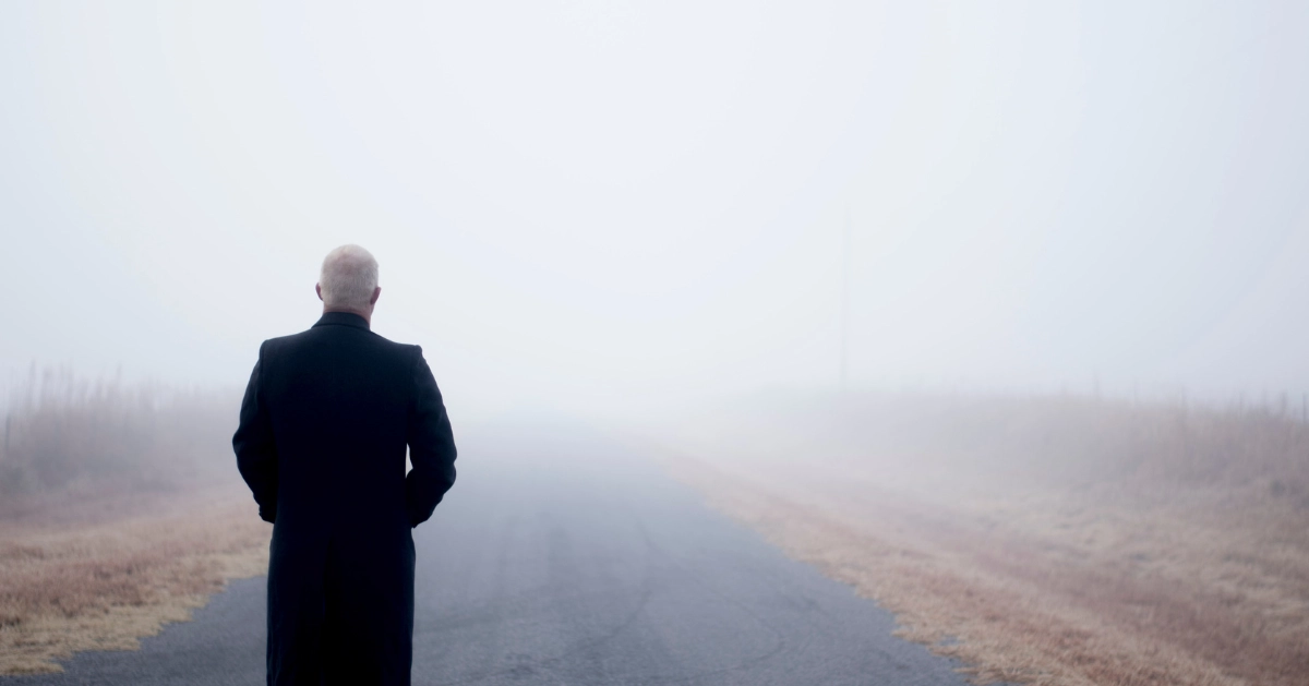 A man standing in the middle of a foggy road