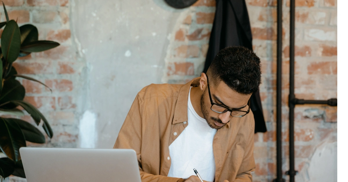 male writing in a journal