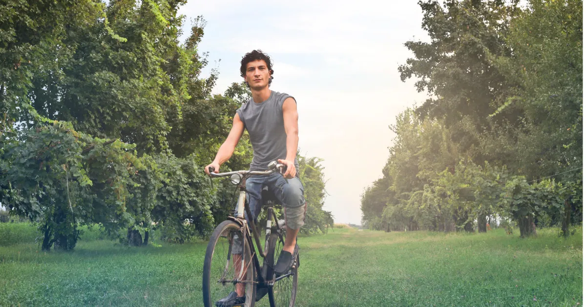 guy outside riding an old bicycle
