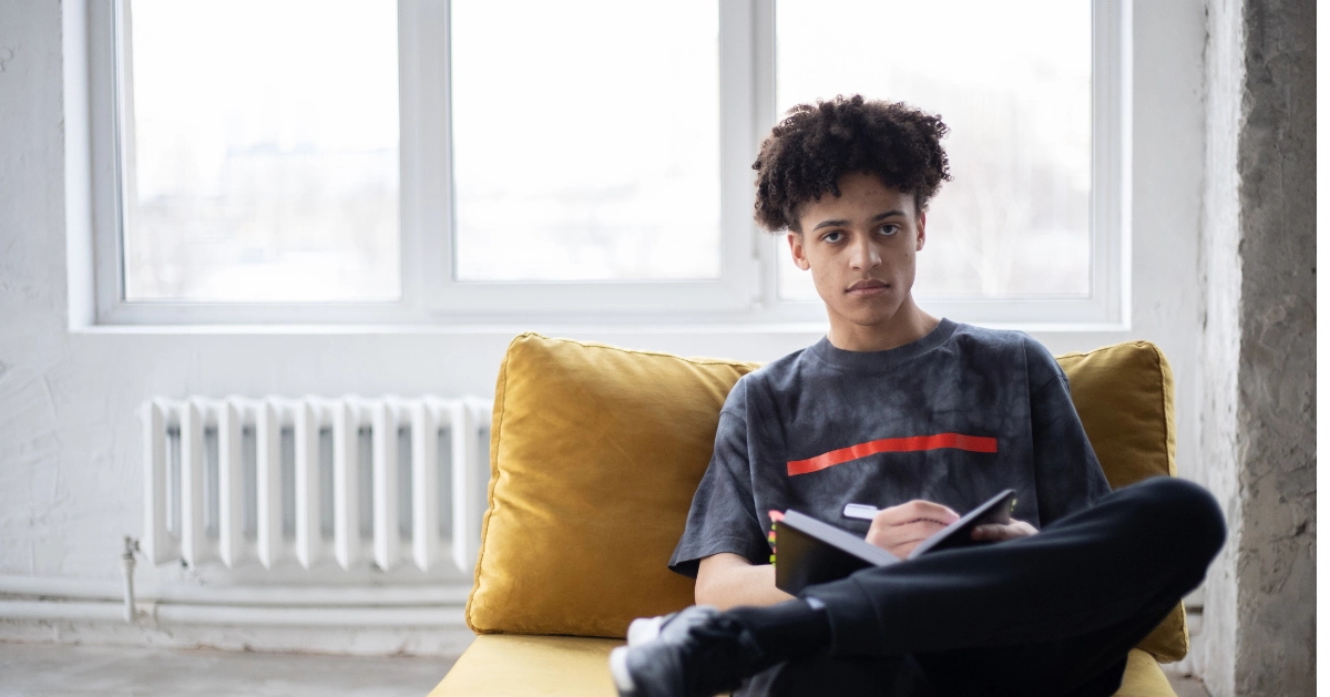 young black man sitting with a book